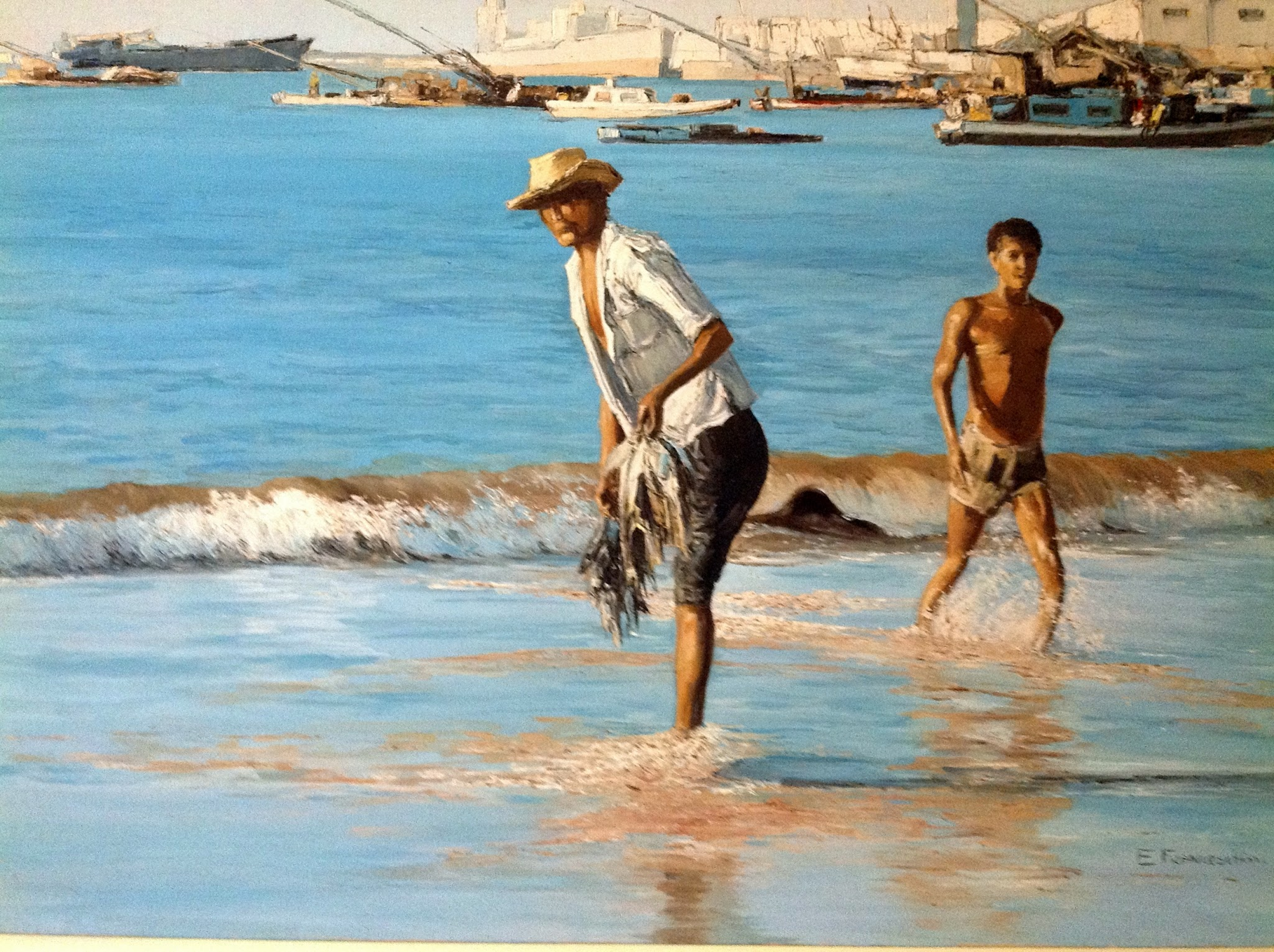Pescado — Pescadores trabalham na água rasa, com barcos ao fundo.